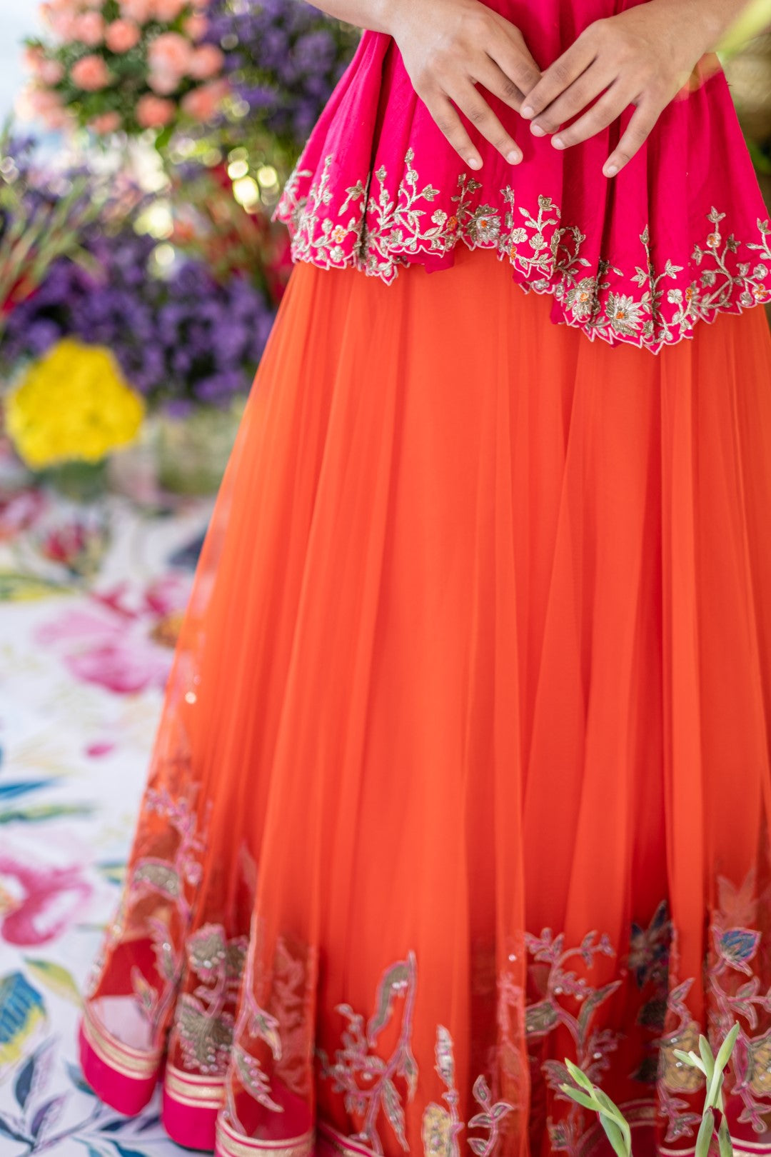 Pop pink embroidered raw silk peplum top with orange net kalamkari embroidered lehenga